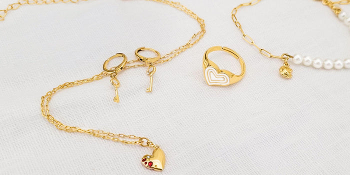 Necklace, bracelet, earrings and a ring curated for the Cancer zodiac sign over a white background.